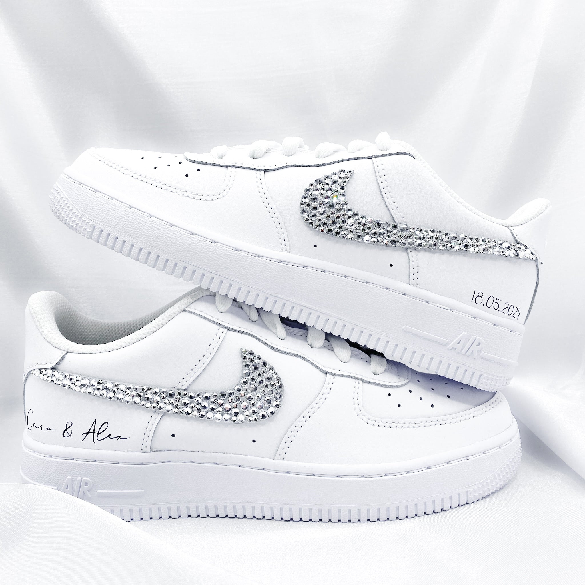 Nike Air Force 1 mit Strasssteinen, die von Hand angebracht wurden. Auf den Schuhen steht in Schreibschrift "Caro & Alex" und "18.05.2024"