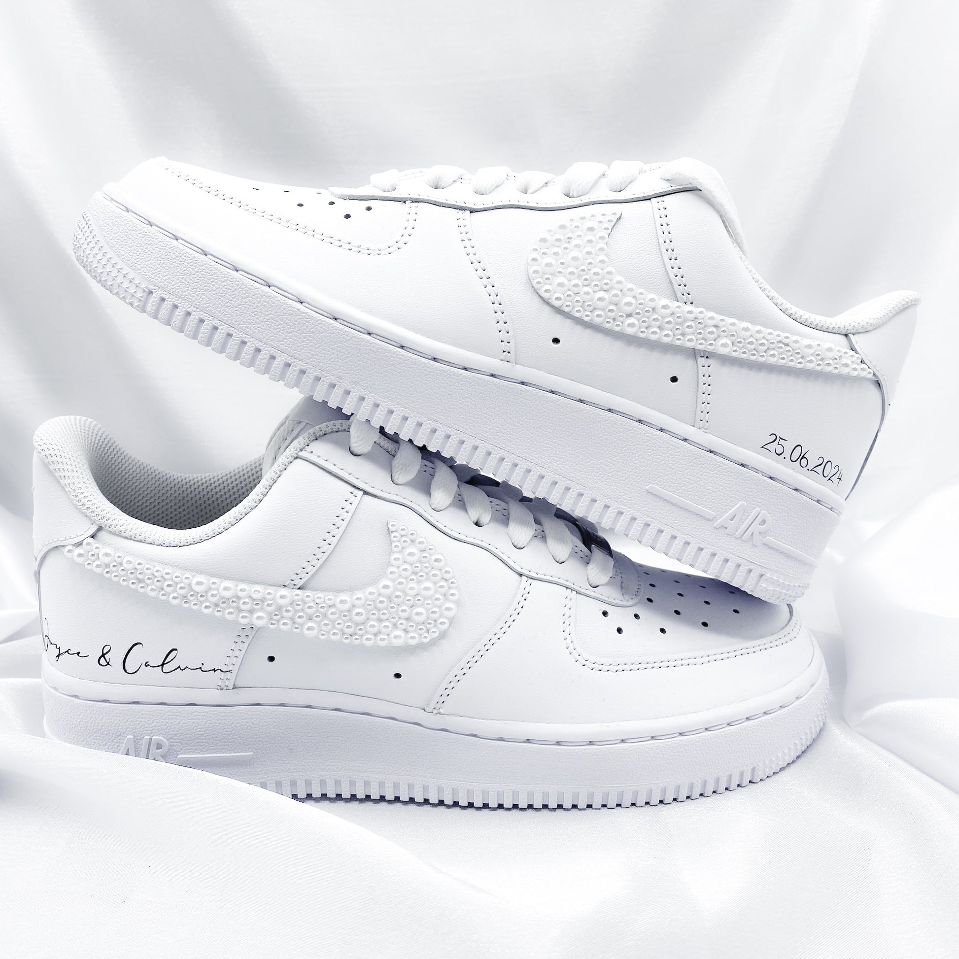 Custom Nike Air Force 1 mit von Hand angebrachten weißen Perlen auf dem Nike Zeichen. Auf den Schuhen steht "Joyce & Calvin" und "25.06.2024"