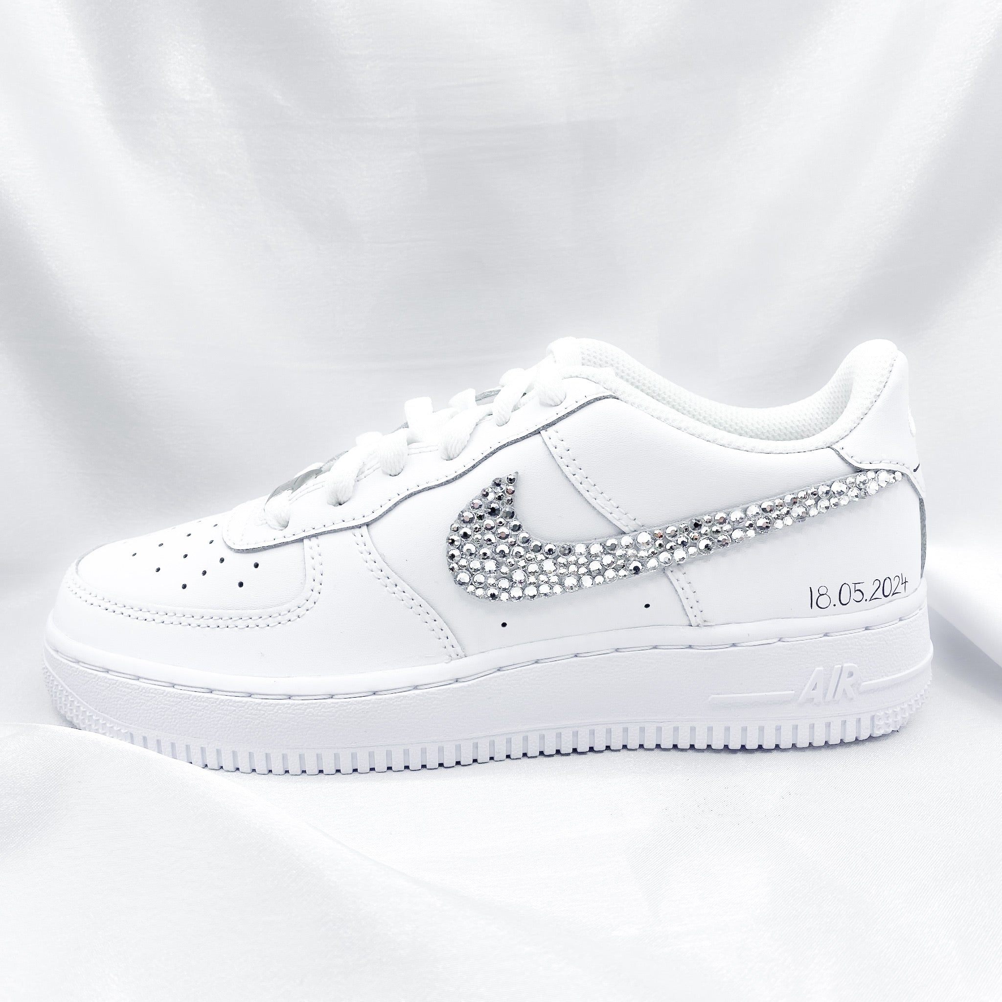 Nike Air Force 1 mit Strasssteinen, die von Hand angebracht wurden. Auf dem Schuh steht in Schreibschrift "18.05.2024" 